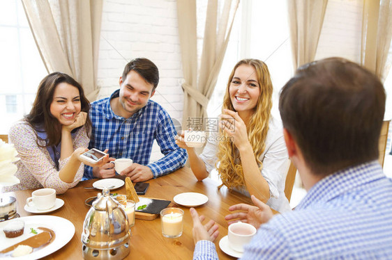 四组快乐的朋友聚会在家里的餐桌上聊天吃图片