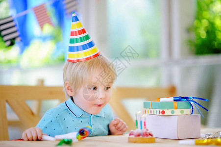 可爱的小男孩用五颜六色的装饰和蛋糕庆祝生日聚会有糖果糖果和节日礼物的孩子学龄前儿童或图片