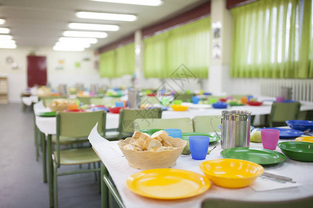 学校餐桌为儿童准备了带眼镜盘子和罐图片