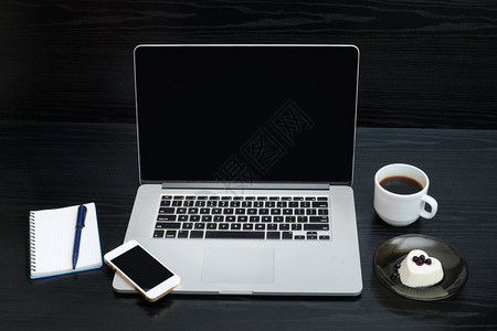 打开笔记本电脑一杯咖啡便条智能电话和图片