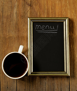 木制背景上带石板粉笔板的咖啡杯图片