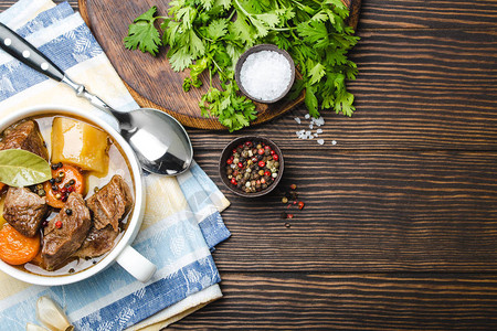 慢煮肉炖在碗里的特写镜头与牛肉土豆胡萝卜肉汤在木制质朴的背景图片