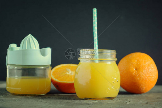罐子里新鲜的橘子汁附近有果汁和橙子美图片