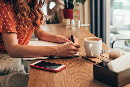 博客在咖啡店用咖啡杯与咖啡一起的桌子上图片