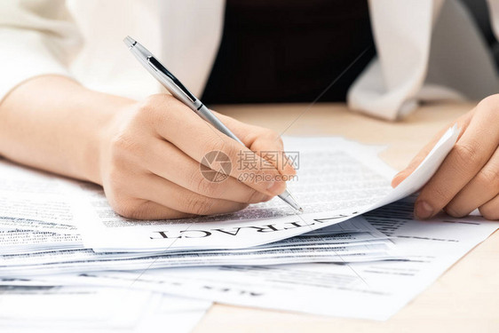 商业妇女签署坐在议席上的合同文件的图片