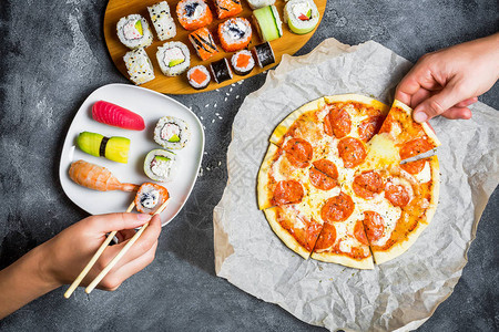 美味的意大利面披萨一套寿司卷和手拿食物深色背景平坦图片