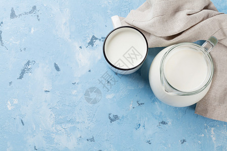 石桌上的乳制品牛奶罐和杯子带有复制空图片