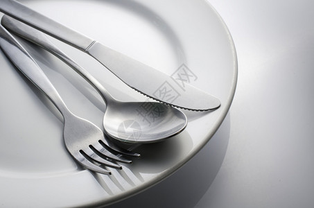 用过的餐具套装在白盘上的叉子图片
