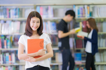 亚洲女学生微笑着和她的朋友教育学生图书馆和大学理念一起在大图片