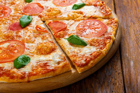美味的意大利玛格丽塔披萨装饰配有巴西尔叶子木本图片