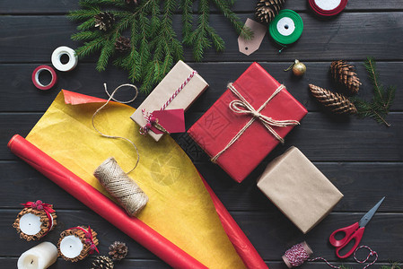 圣诞节礼品和木制桌上包装纸的构成图片