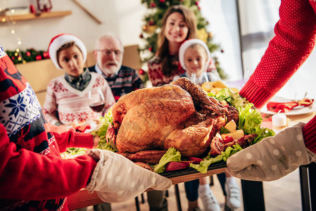人们带火鸡与家人在家中共进圣诞节晚宴的图片
