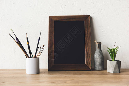 木制桌面上的空照片框花瓶和图片