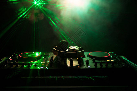 DJ之手调整dj甲板上的各种轨道控制频闪灯和雾图片