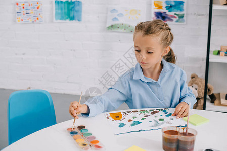 油画长城绘画与桌边刷笔画的彩色图片在桌子背景