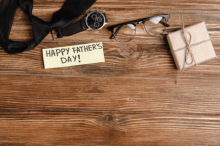 礼物盒的顶端视图带快乐父亲日信函的贺卡和男子黑色领带手表图片