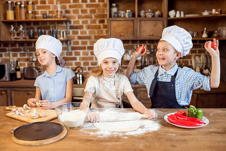 儿童在厨房做比萨饼面团和准图片