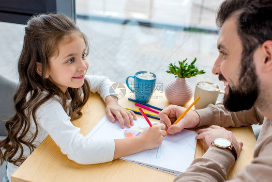 女儿和父亲笑着画在一起互相看着对方图片