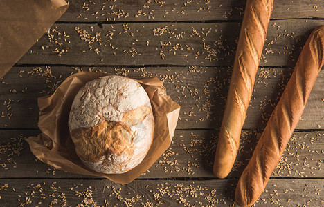 木制桌上新鲜袋式面包和全小麦面图片