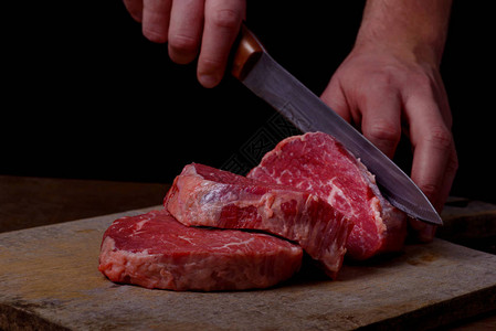 屠夫切牛肉在厨房做牛排背景图片