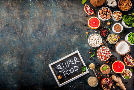 一套有机健康饮食品超级食品豆类豆类坚果种子绿色水果和蔬菜深蓝色背景复图片