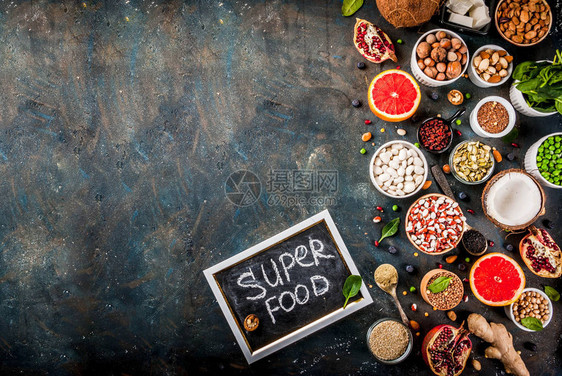 一套有机健康饮食品超级食品豆类豆类坚果种子绿色水果和蔬菜深蓝色背景复图片
