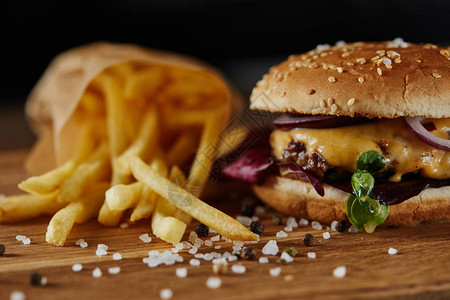 食盐薯条和美味汉堡以及木制表面肉类图片
