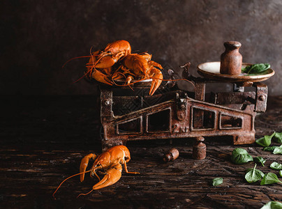 近距离观察古代天平上美味龙虾和生锈木制餐图片
