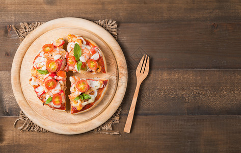 木材背景的海鲜比萨饼带有复制空图片