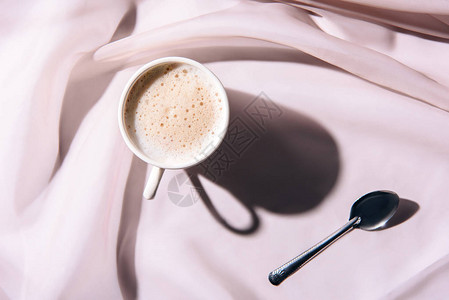 粉色桌布上咖啡和勺图片