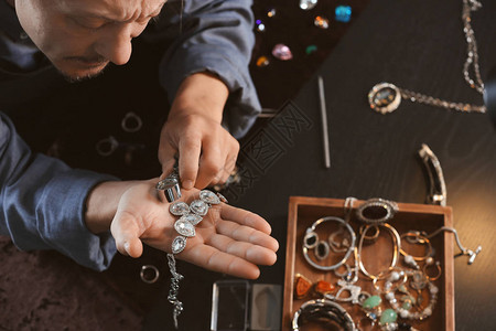 珠宝商检查项链中的宝石图片