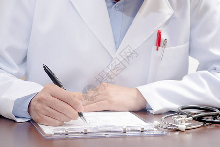 一名男医生在医疗表格上写了字图片