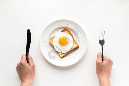 以白隔绝的烤面包用煎蛋吃早餐的图片