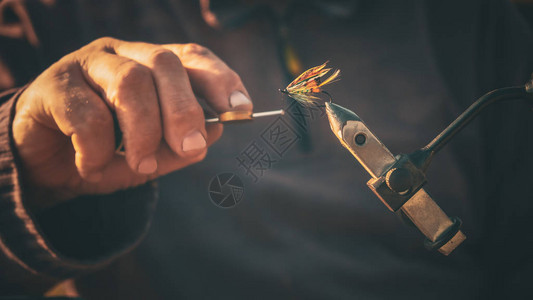 渔夫绑苍蝇钓鱼的特写图片