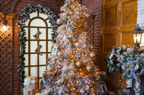 圣诞魔法美丽的装饰白色圣诞树在舒适的客厅闪亮的灯光小玩意和花环寒假神奇的气氛现代设计和装图片