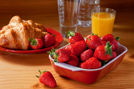 美味的早餐包括羊角面包和草莓图片