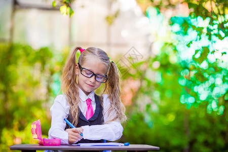 快乐的小女学生带着笔纸和铅图片