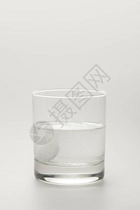 泡腾丸在一杯水中的白色隔离图片