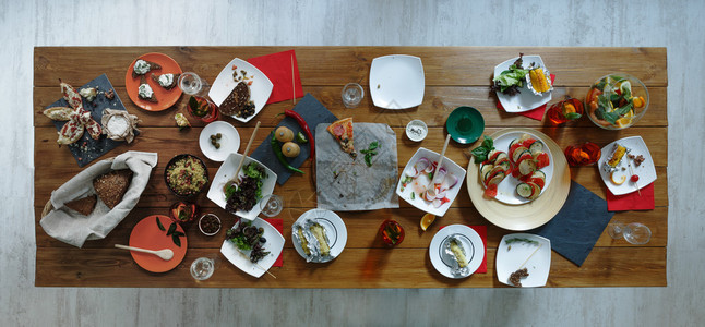宴会结束后晚宴后在木制节日餐桌上浪费食物剩菜饭背景图片