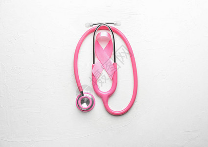 光背景的粉色丝带和听诊器乳图片