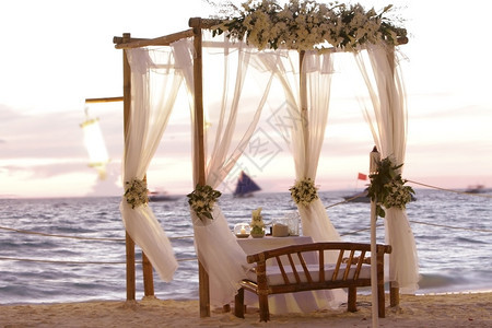 日落海滩上的婚礼桌装饰非露天餐厅图片
