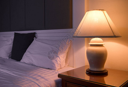 经典床旁边的床头柜上的灯图片