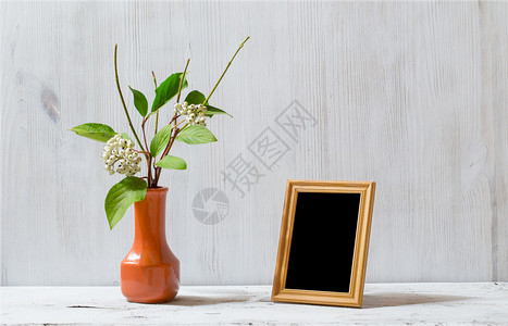 旧白桌上的相框和鲜花图片