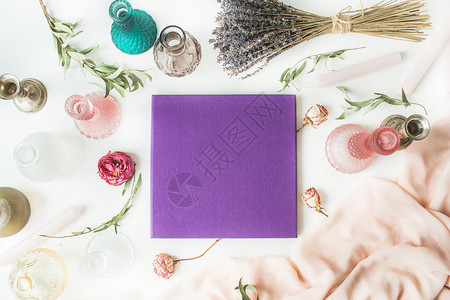 紫色婚礼或家庭相册玫瑰薰衣草绿色桉树枝蜡烛台白色背景上的粉色连衣裙图片