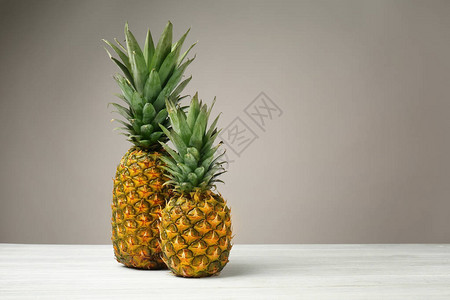 灰色背景下木桌上的美味菠萝背景图片