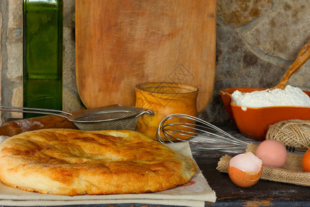 传统的意大利面包佛卡夏面包蛋黄碎蛋石墙背景上的全蛋和餐具风格侧视图特写图片