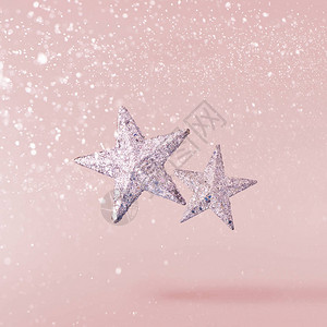 圣诞节的概念创意圣诞构想是在粉红色背景下坠入空中银星图片