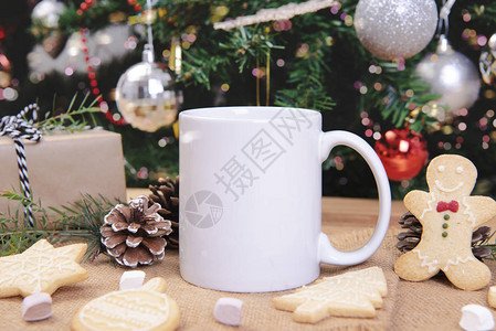 白陶咖啡杯和在Woon桌背景上的圣诞节装饰品创造广告短信或促销内图片