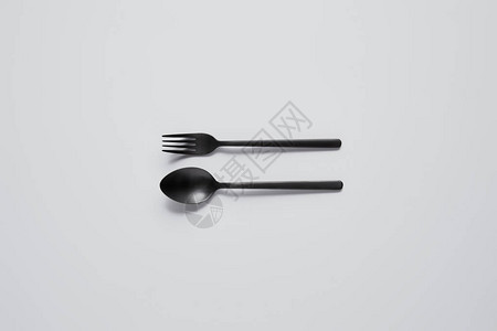黑勺子和白桌上叉子的顶部视图片