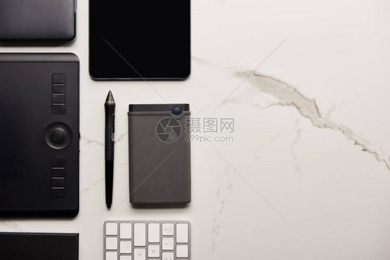 在白色大理石表面用带有便携式hdd和无线键盘的图形和数字平图片